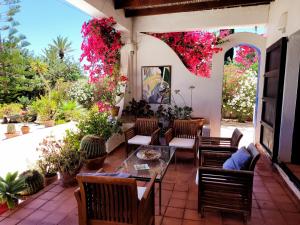 a patio with a table and chairs and flowers at LOS MORALICOS AGUA AMARGA in Agua Amarga