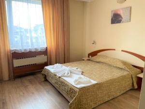 una camera d'albergo con un letto e una finestra di Family Hotel Central a Burgas