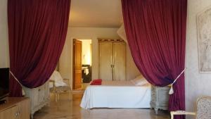 a bedroom with red drapes and a bed in a room at Hotel Rural Can Maries in Puerto de San Miguel