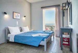 a bedroom with a bed with a view of the ocean at Star Apartments in Rethymno Town