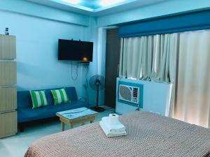 a blue bedroom with a bed and a couch at Apartments across NAIA Terminal 3 in Manila