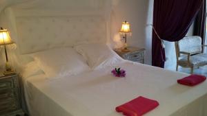 a white bed with two red napkins and flowers on it at Hotel Rural Can Maries in Puerto de San Miguel