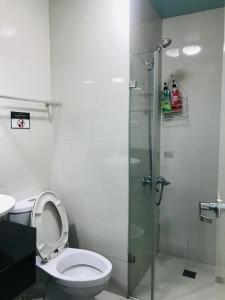 a bathroom with a toilet and a glass shower at Apartments across NAIA Terminal 3 in Manila