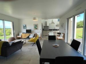 ein Wohnzimmer mit einem Tisch und Stühlen sowie ein Wohnzimmer in der Unterkunft Maison 3* avec Terrasse, Confort Moderne, Proche Plages et Randonnées - FR-1-542-53 in Trégastel