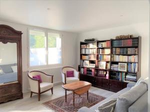 a living room with a book shelf filled with books at Maison rénovée 3 étoiles à 150m de la plage, idéale pour familles avec espace enfants et Wifi - FR-1-481-116 in Bénodet