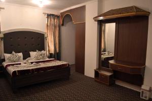 1 dormitorio con cama y espejo grande en Hotel Al Azrah, en Srinagar