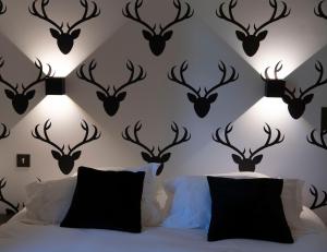 un dormitorio con cabezas de ciervo negro en la pared en Chalet Appart'Hôtel l'Eau Vive en Saint-Nicolas-la-Chapelle