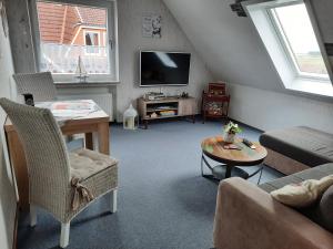 ein Wohnzimmer mit einem Sofa und einem Tisch in der Unterkunft FeWo Fuhrmann in Bensersiel