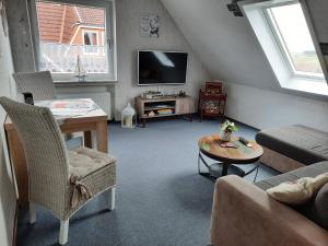 a living room with a couch and a table at FeWo Fuhrmann in Bensersiel