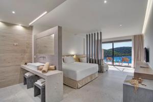 a bedroom with a bed and a sink and a mirror at Sivota Deamaris Luxury Boutique Hotel in Syvota