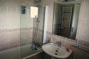 a bathroom with a sink and a tub and a shower at Casa das Palmas in Óbidos