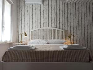 ein Schlafzimmer mit einem großen Bett mit zwei Handtüchern darauf in der Unterkunft Colleoni 19 in Civitanova Marche