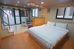 a bedroom with a large bed in a room with windows at 礁溪玥湯溫泉旅店 in Jiaoxi