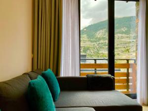 a living room with a couch and a large window at Prober La Cabaneta in Canillo