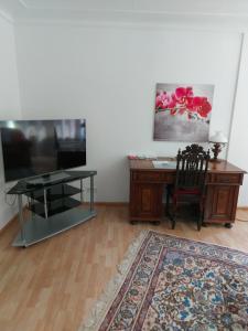 a living room with a desk and a table and a chair at Ferienwohnung in Bad Eilsen in Bad Eilsen