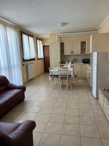 uma cozinha e sala de estar com mesa e frigorífico em Casa Mimì em Arsago Seprio
