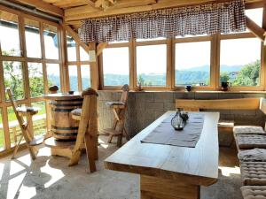 a room with a wooden table and a large window at Holiday house Aronija in Šmarje pri Jelšah