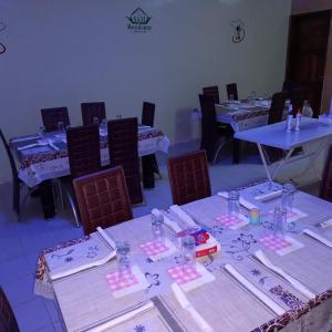 a group of tables and chairs in a room at SAM RESIDENCE Jàmm ak Cofeel in Saint-Louis