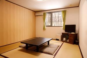sala de estar con mesa y TV en Paper Moon en Nasu