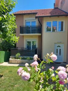 a house with pink flowers in front of it at Apartmani MALINA in Vrnjačka Banja