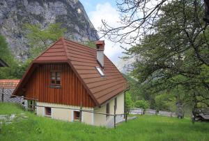 a small house with a brown roof in a field at Zadnjica Holiday House in Soča