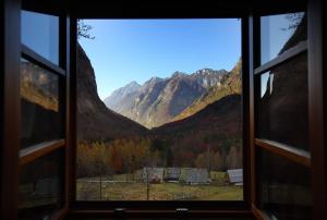 a window with a view of a mountain range at Zadnjica Holiday House in Soča +2 photos