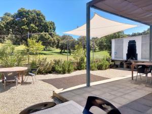 un patio con una tienda, mesas y sillas en Casa Rural Nacimiento del Huéznar - Tomillo 17, en San Nicolás del Puerto