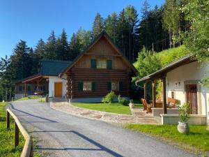 a log cabin with a road next to a house at Schilcherland Chalet Südsteiermark in Trahütten