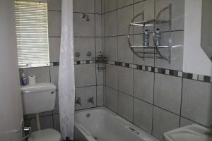a bathroom with a tub, toilet and sink at Sabie Star in Sabie