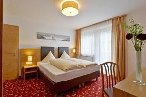 sypialnia z łóżkiem i stołem oraz wazonem kwiatów w obiekcie Gästehaus Alpengruss w Mayrhofen