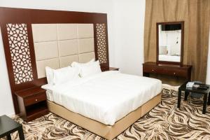 a bedroom with a large bed and a mirror at Al Farhan Dumah Al Jandal in Dawmat al Jandal