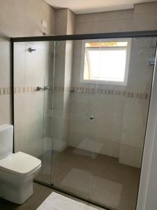um banheiro com box de vidro e vaso sanitário em Apartamento na Montanha em Campos em Campos de Jordão mais 13 fotografias