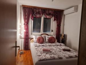 1 dormitorio con 1 cama grande y cortinas rojas en EMRAH RIVER UNA, en Bihać