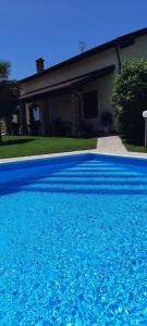 a blue swimming pool in front of a house at Villa Lara in Marsaglia
