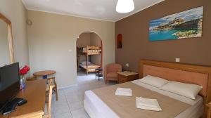 1 dormitorio con 1 cama y escritorio con TV en Moka Evia Island, en Trikovilón