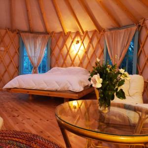 a room with a bed in a yurt with a glass table at Love Frequency - יורט קסום במתת in Mattat