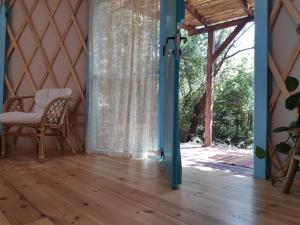 an open door to a room with a chair and a window at Love Frequency - יורט קסום במתת in Mattat