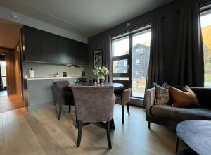 una cucina e un soggiorno con tavolo e sedie di Snøya Lodge a Hemsedal