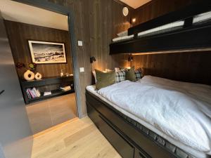 a bedroom with a bed with a wooden wall at Snøya Lodge in Hemsedal