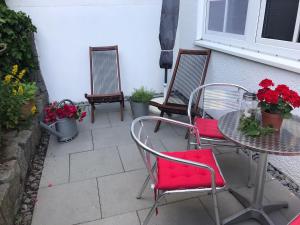 a table and chairs with flowers on a patio at Modernes Apartment mit Terrasse und Highspeed Internet zwischen Aalen und Schwäbisch Gmünd in Göggingen +3 photos