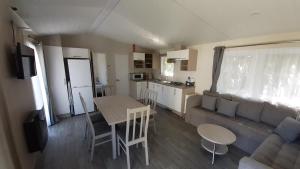 een woonkamer en een keuken met een bank en een tafel bij Landbouwlust Chalet Melrose in Serooskerke