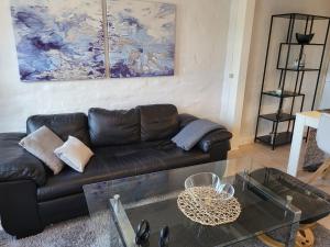 a living room with a leather couch and a glass table at City Harbour House in Sønderborg +53 photos