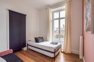 a bedroom with a bed and a large window at Victoria Belle Vue in Saint Malo