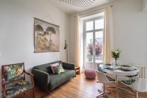 a living room with a table and a chair at Victoria Belle Vue in Saint Malo