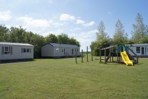 a park with a slide and a playground at Landbouwlust Chalets in Serooskerke