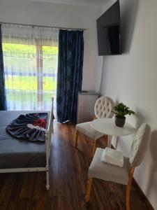 a bedroom with a bed and a table and chairs at Vila SIA Eforie Sud in Eforie Sud