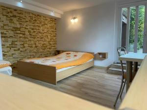 une chambre avec un lit et un mur de briques dans l'établissement Willa Sara, à Ustka