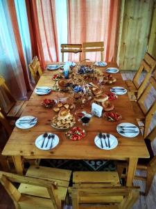 een houten tafel met borden eten erop bij Guest house CBT Chon-Kemin in Shabdan
