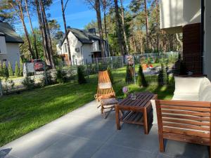 een patio met 2 banken en een tafel bij Domek Pod Sosnami in Rozewie