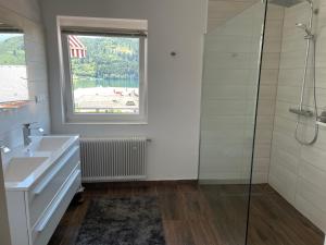 a bathroom with a sink and a window and a shower at Seeblick Millstatt in Millstatt